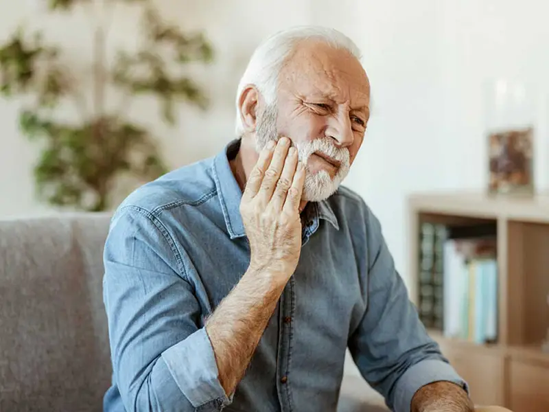 Older man experiencing tooth pain | Dentist in Georgetown